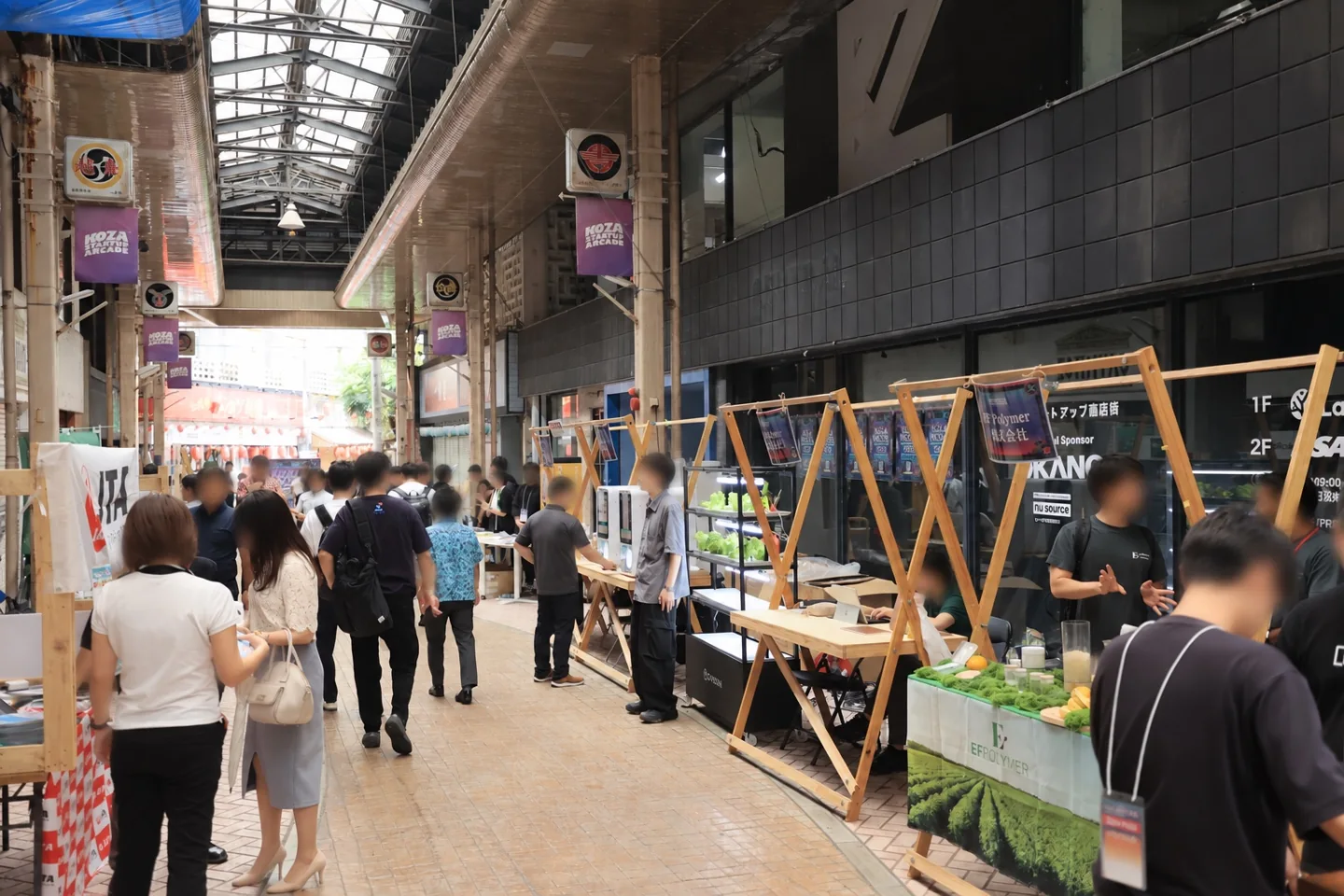 展示ブースと人々が集まるコザのアーケード